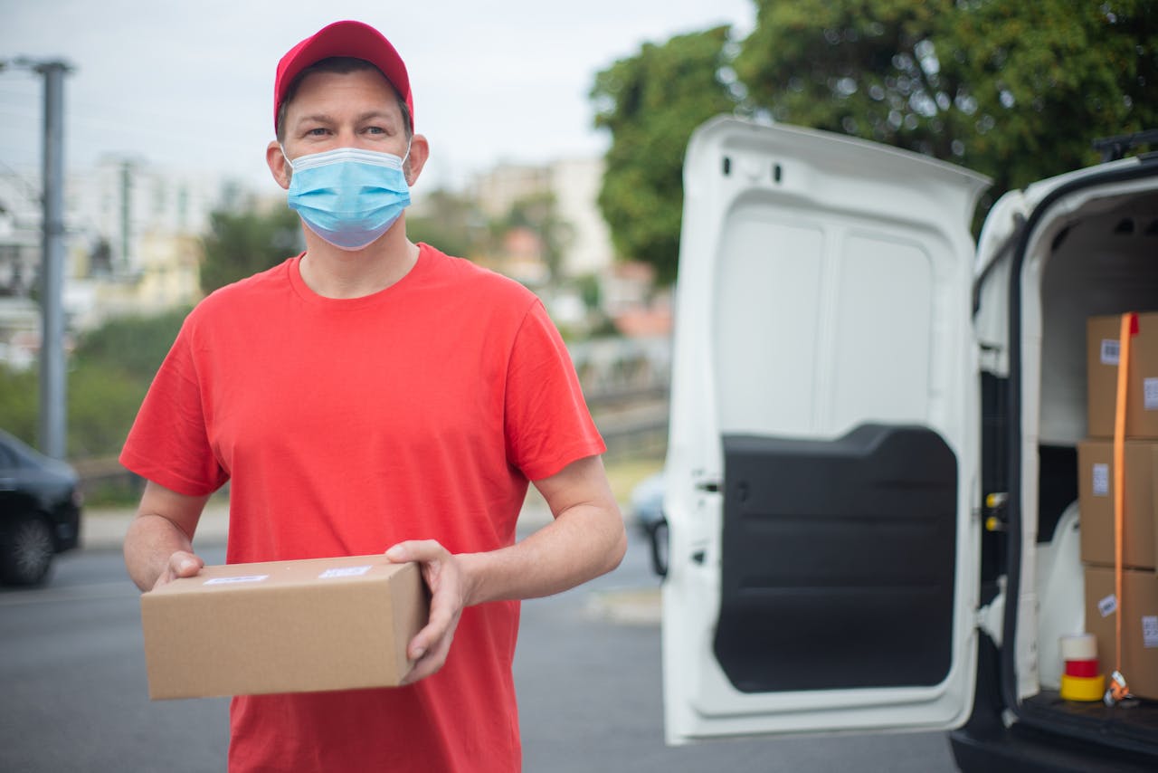 Courier in red delivering packages, wearing a mask outdoors in Portugal.